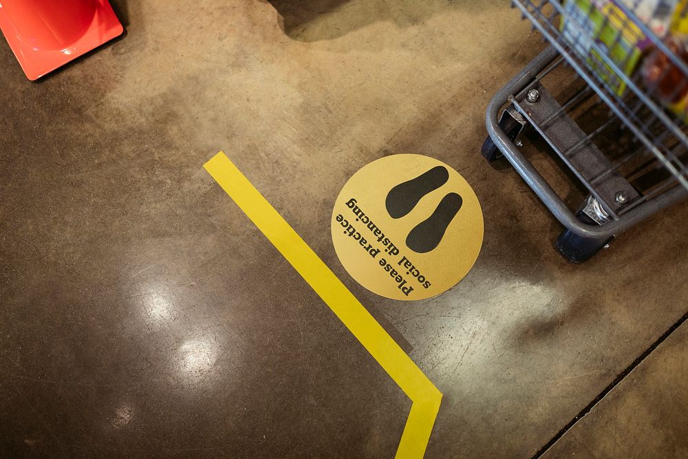 Supermarket social distancing sign on the ground during coronavirus pandemic