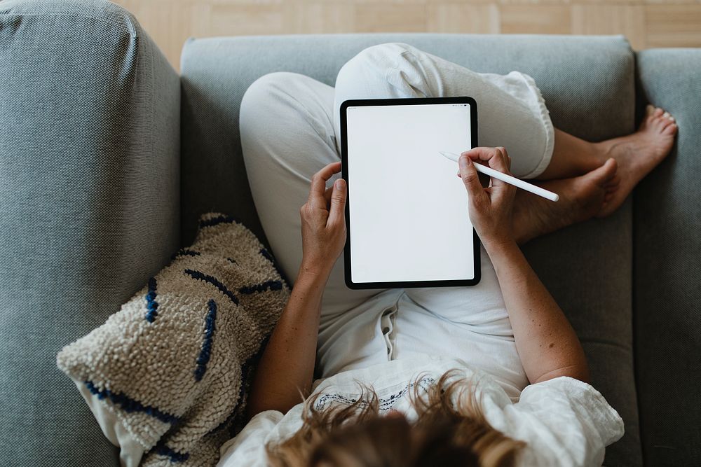 Woman using a stylus with a digital tablet during coronavirus quarantine at home