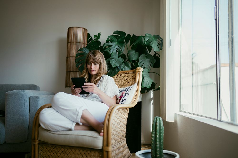 Woman reading an e-book on a digital tablet  during coronavirus quarantine