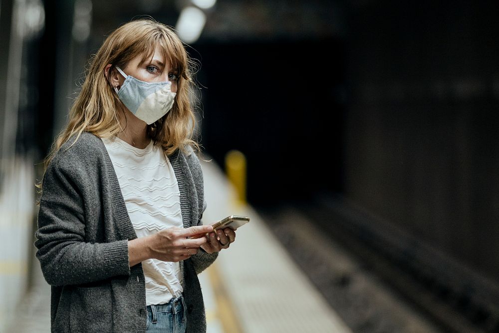 Woman wearing a mask while waiting for the train during the coronavirus pandemic 