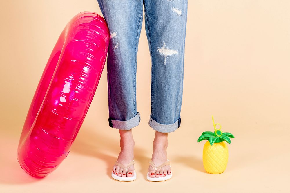 Woman in ripped jeans standing with a pink 