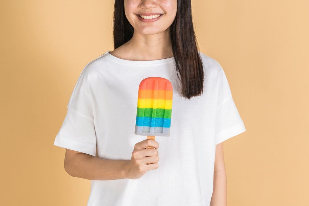 Woman with a rainbow ice pop in summertime