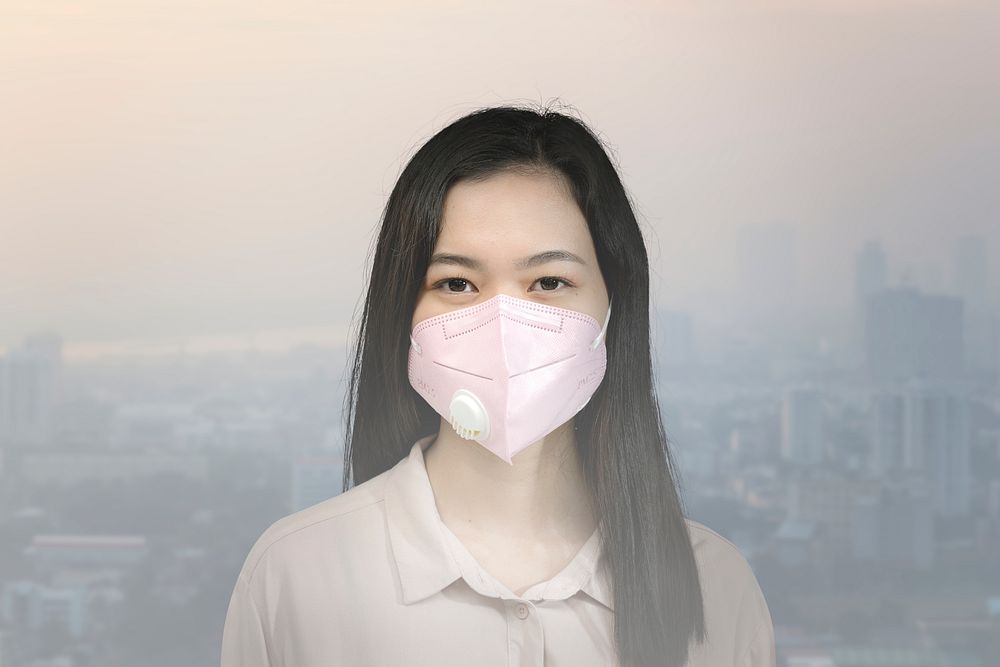Asian woman wearing a mask in a polluted city