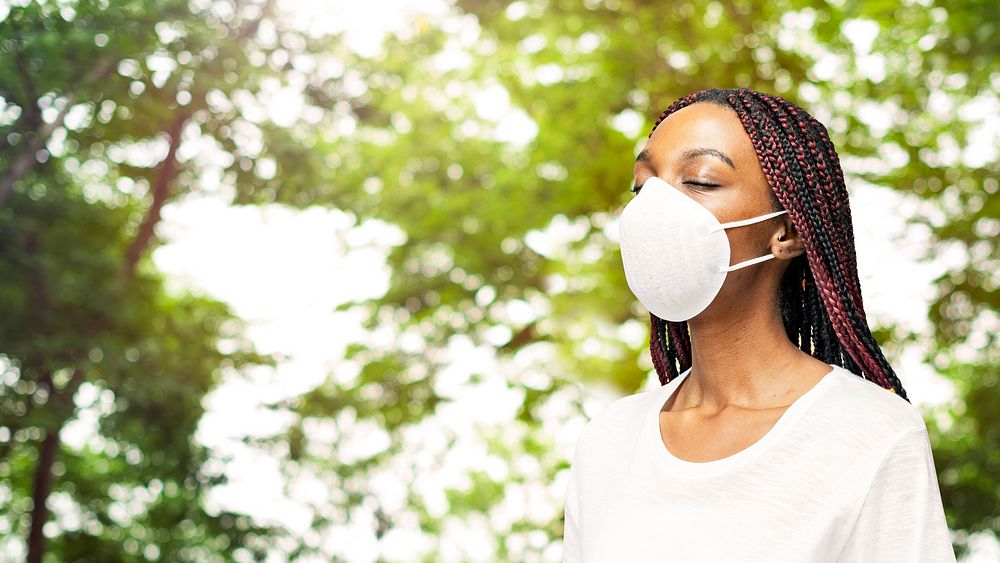 Black woman wearing an air pollution mask in a park