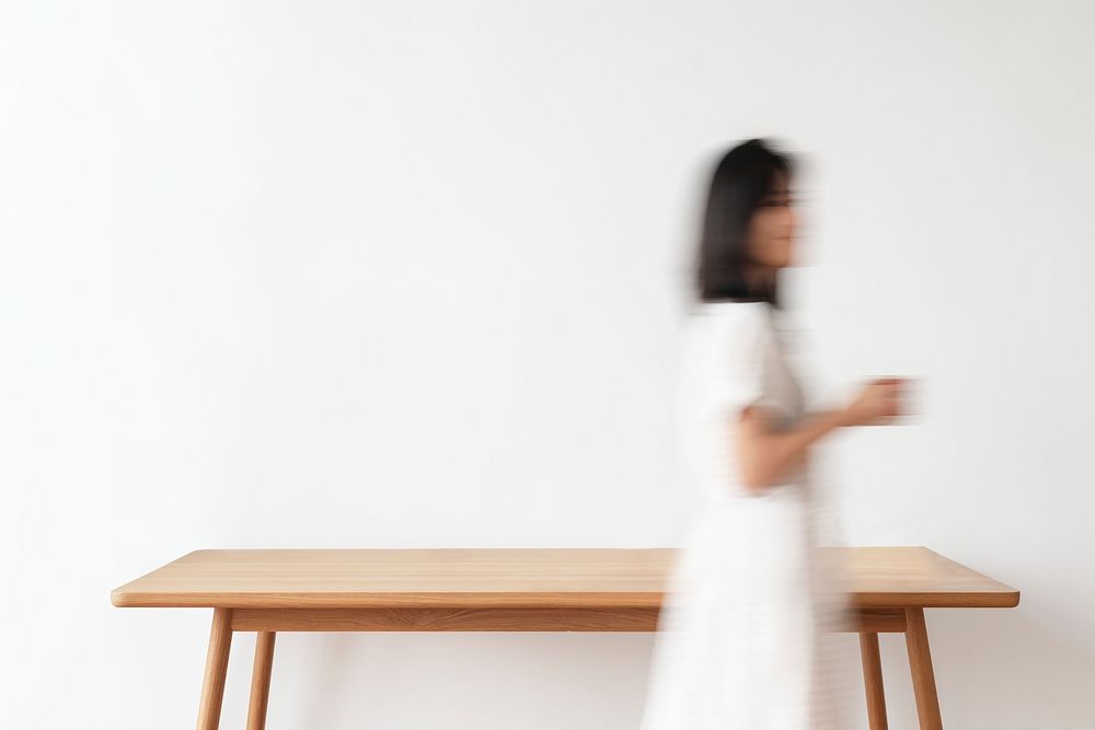 Blurry woman walking with a cup of coffee in her hand