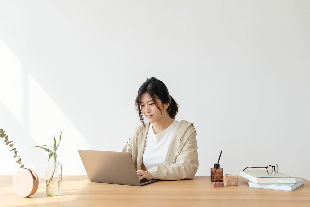 Happy Asian woman at home using a a laptop 