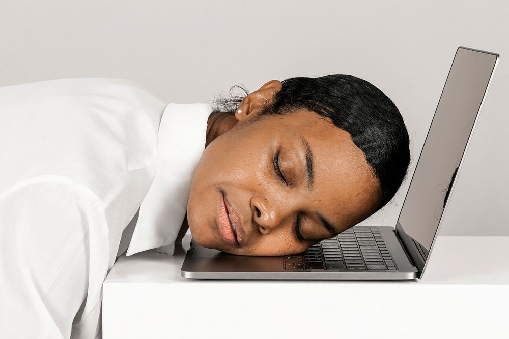 Exhausted black woman asleep on a laptop 