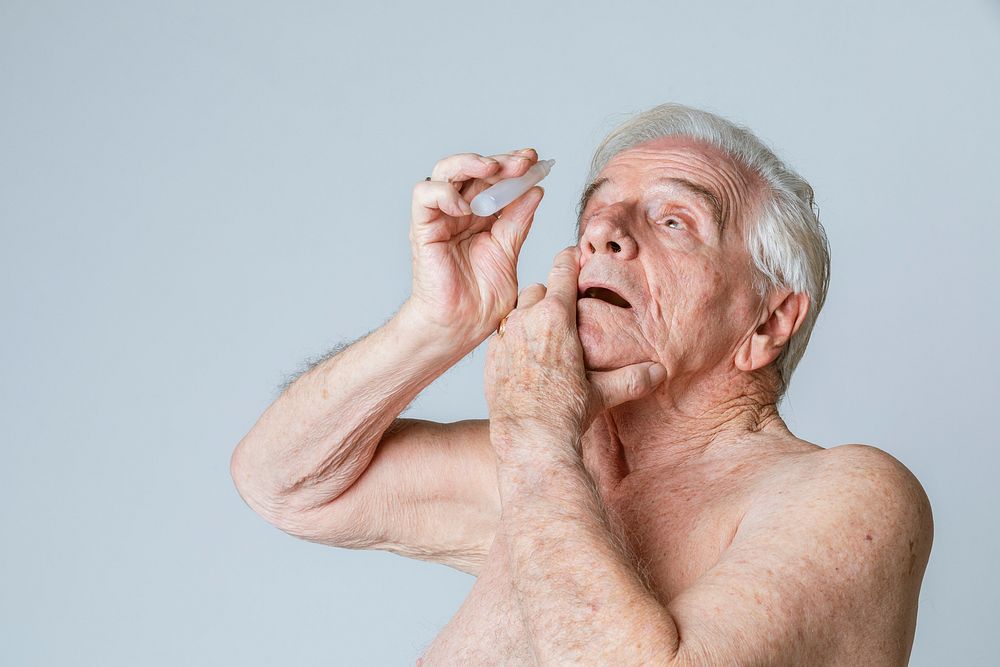 Senior man applying eye drops