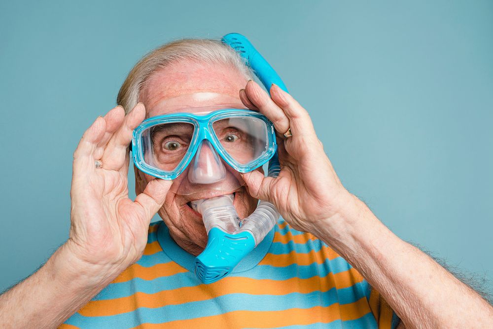 Cheerful senior man wearing a snorkel and scuba mask
