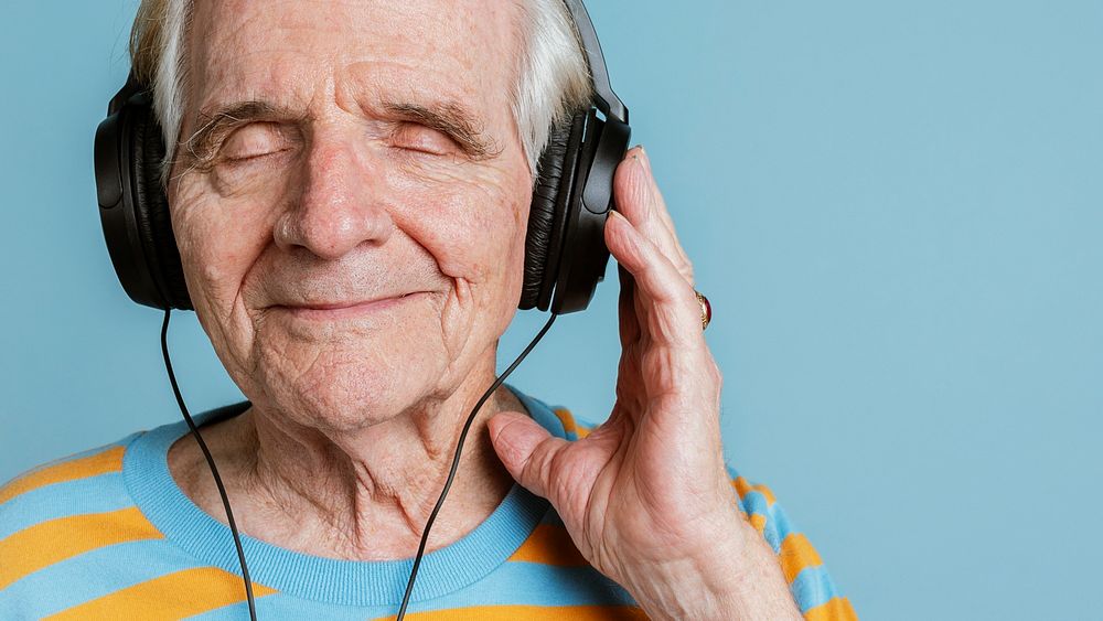 Happy senior man listening to music with headphones 
