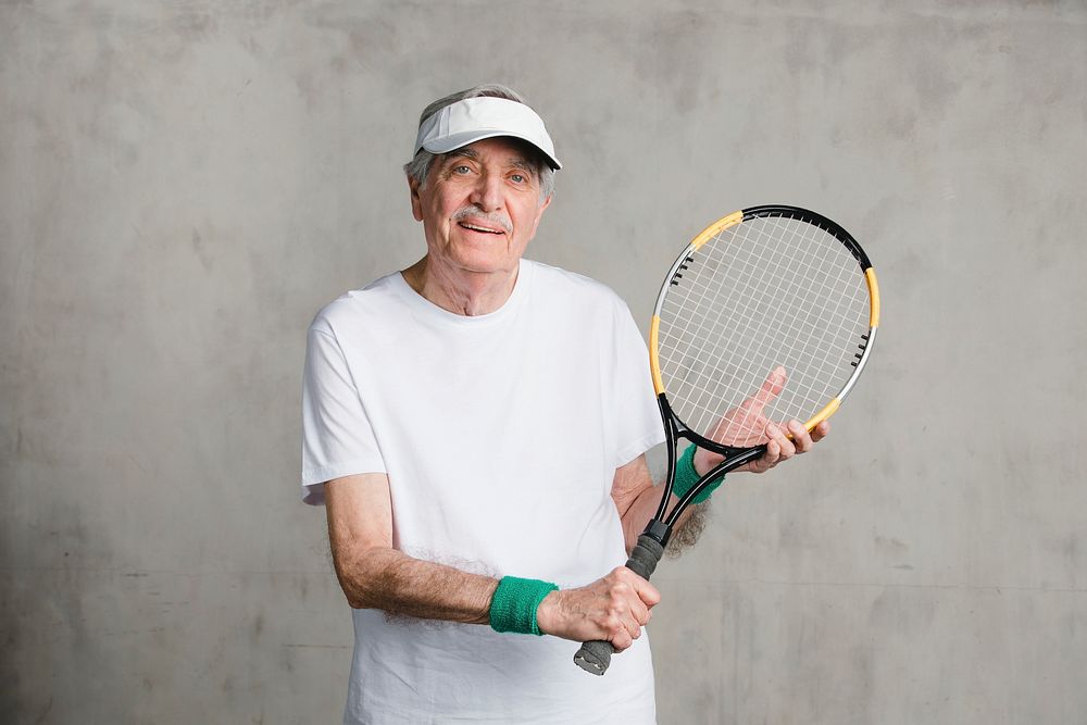 Cheerful senior man with a tennis racket