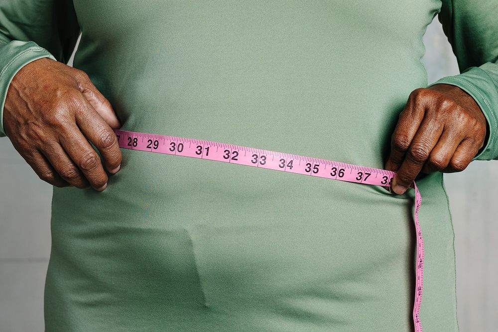 Black woman measuring her tummy 