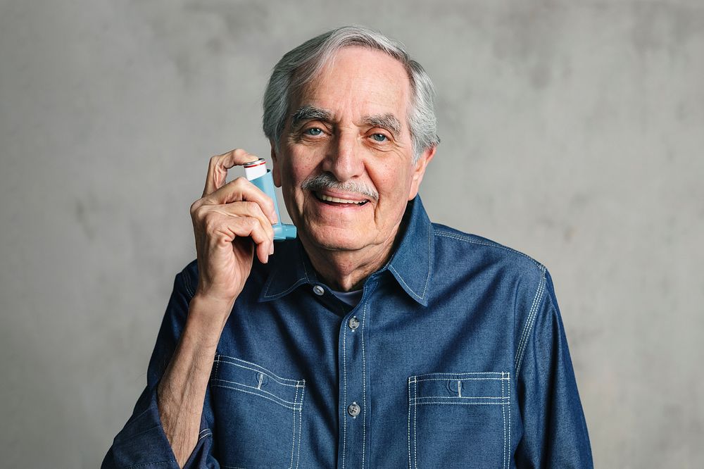 Senior man using an inhaler 
