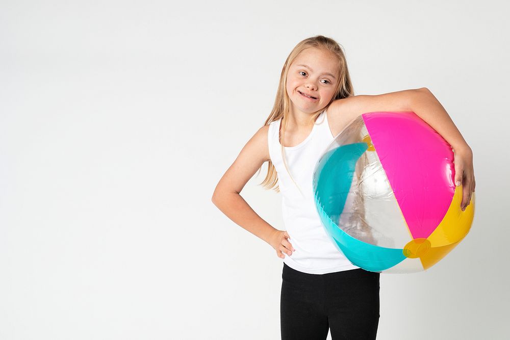 Cute little girl with Down Syndrome with a beach ball