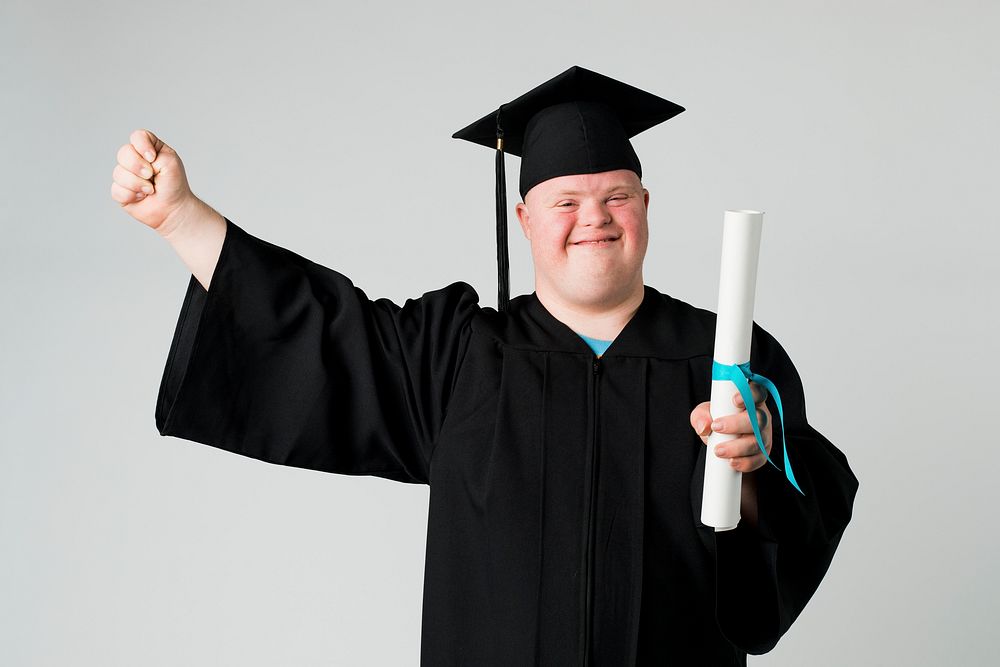 Happy boy with down syndrome in a graduation gown