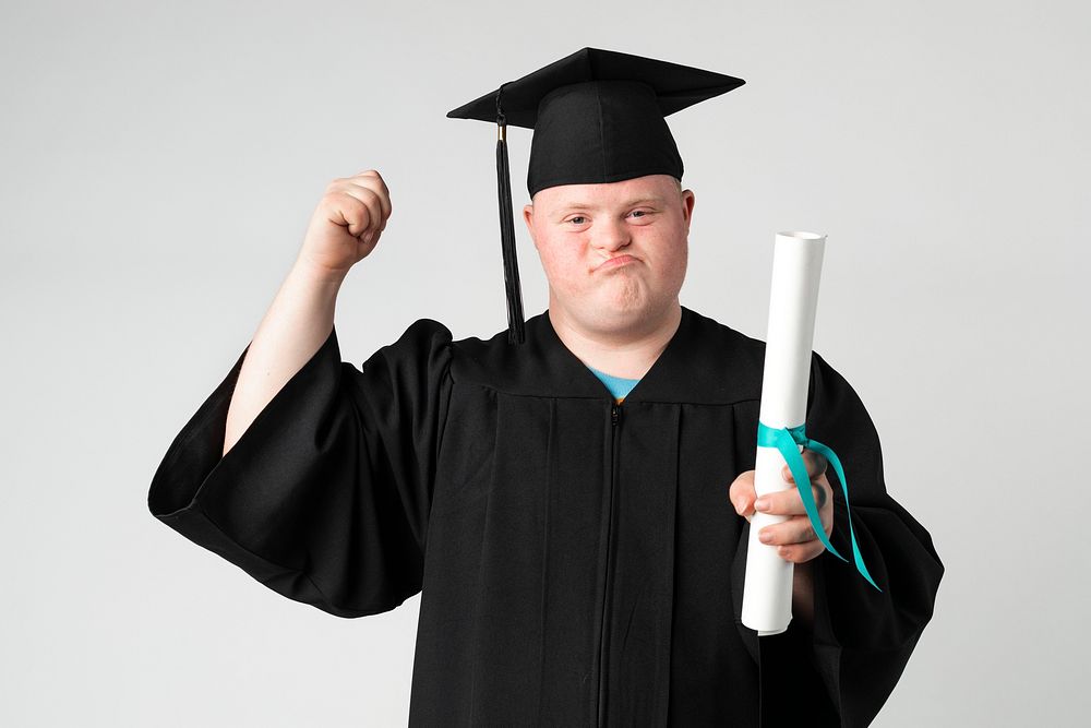 Proud boy with down syndrome in a graduation gown