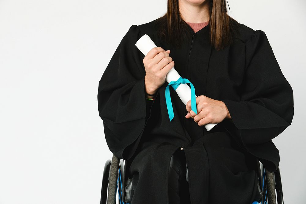 Happy girl in a wheelchair holding her diploma 
