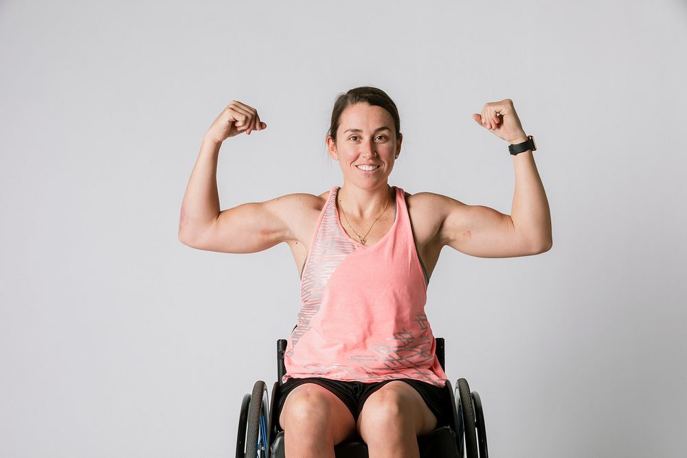 Athlete in a wheelchair flexing her arms 