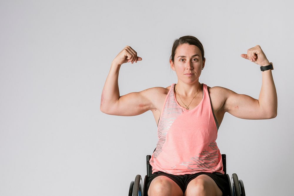 Athlete in a wheelchair flexing her arms 