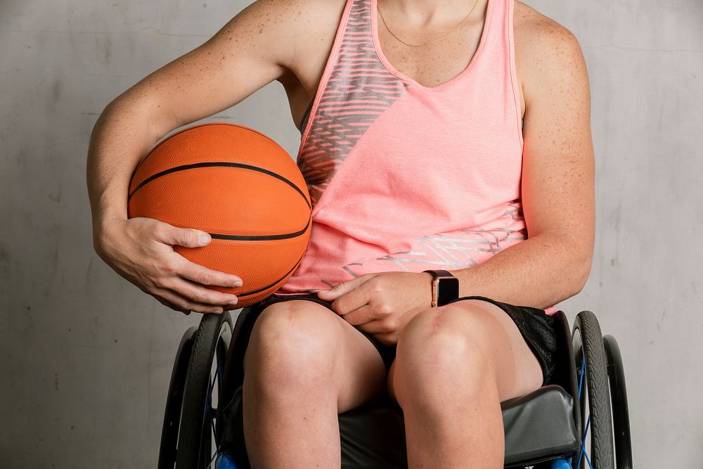 Female athlete in a wheelchair holding a basketball