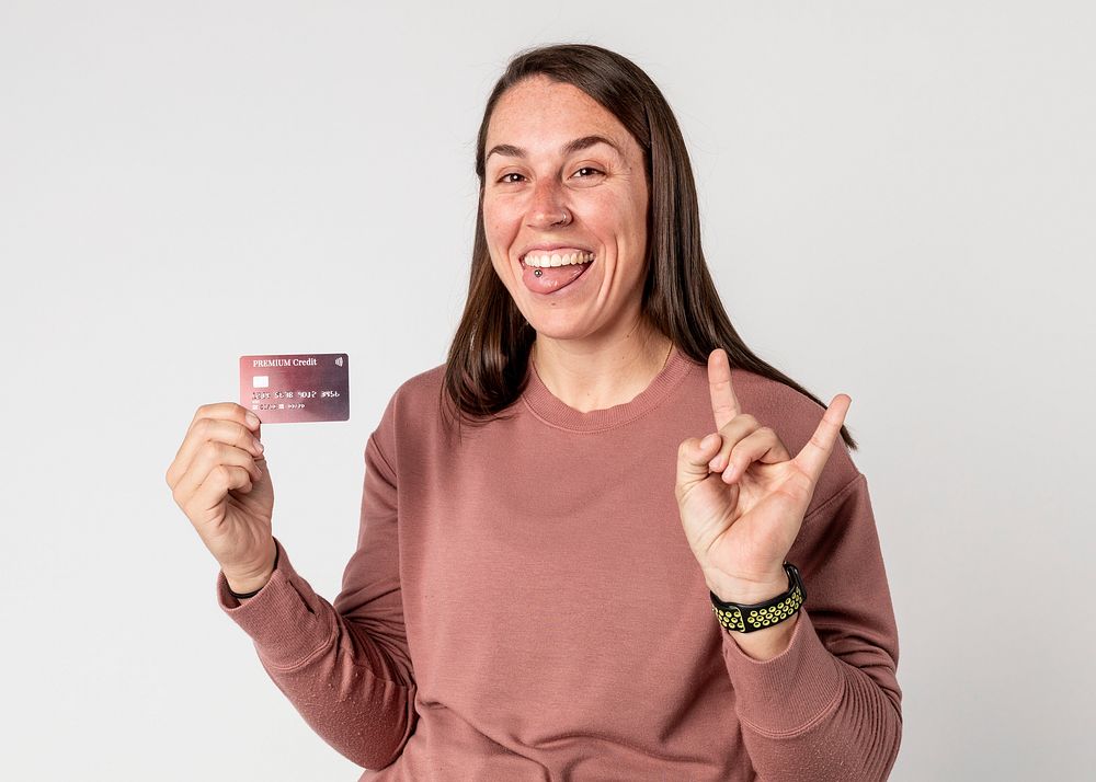 Woman sticking her tongue out while showing a premium card