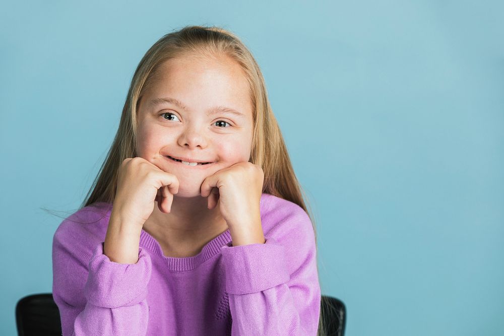 Cute girl with Down Syndrome in a purple sweater