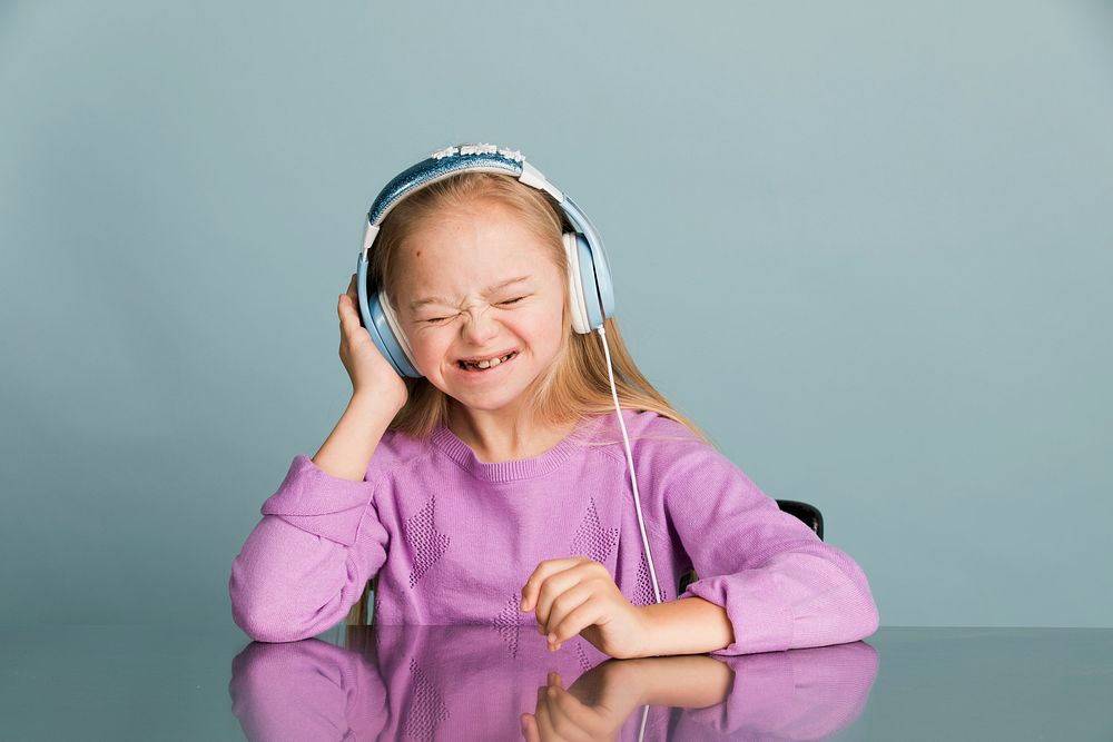Cute little girl with Down Syndrome listening to music