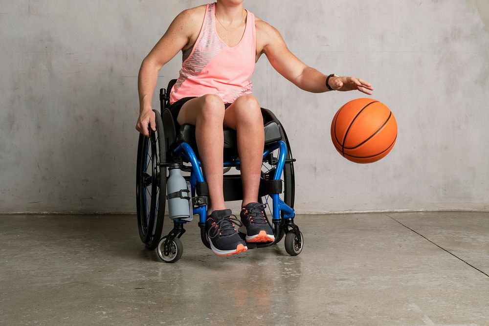Female athlete in a wheelchair dribbling a ball