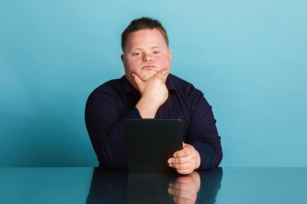 Confident boy with down syndrome homeschooling using a digital tablet during the coronavirus pandemic