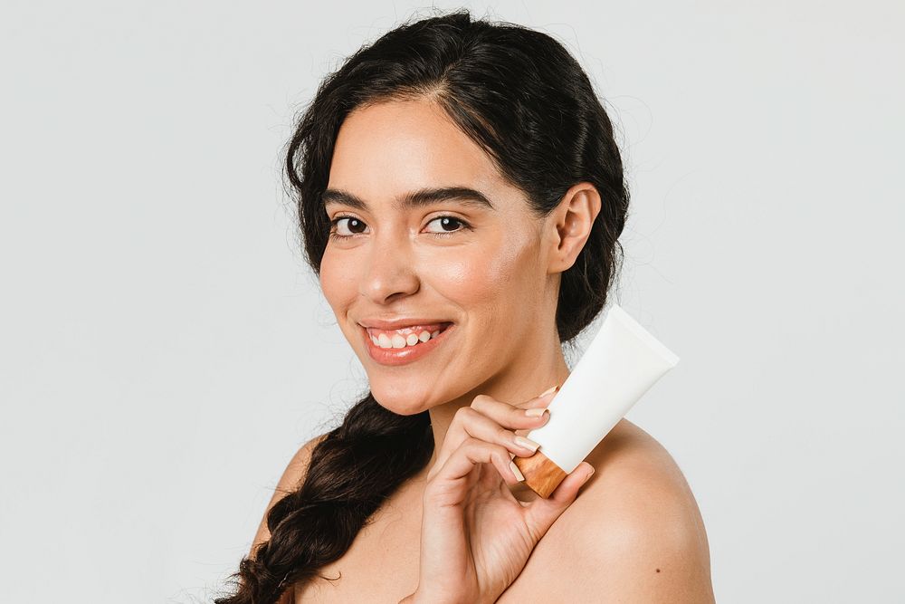 Beautiful woman holding a skin care product