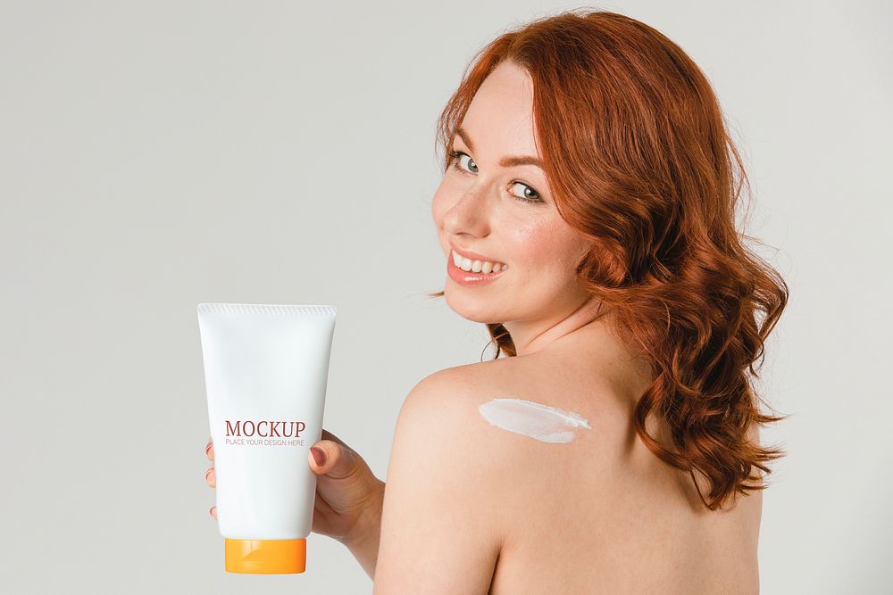Cheerful woman holding a skin care product mockup