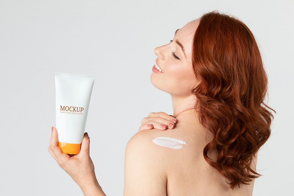 Cheerful woman holding a skin care product mockup