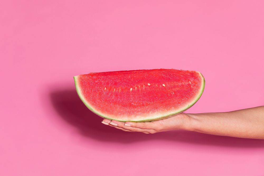 Woman holding a juicy slice of watermelon 