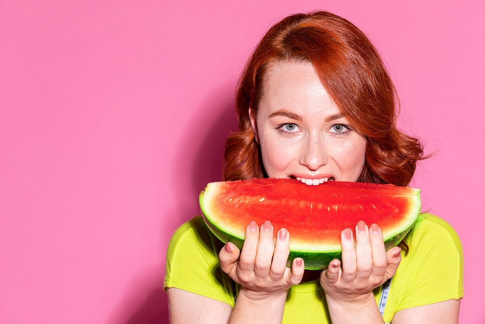 Woman biting into a slice of watermelon