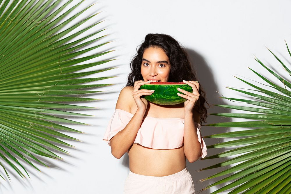 Happy woman biting into a slice of watermelon