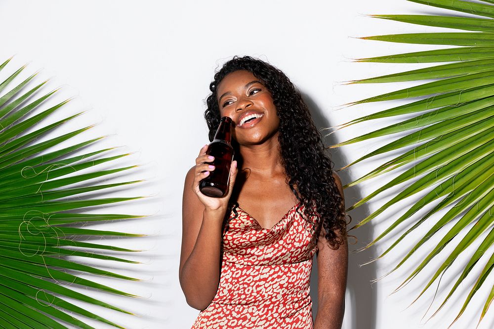 Happy black woman holding a beer bottle