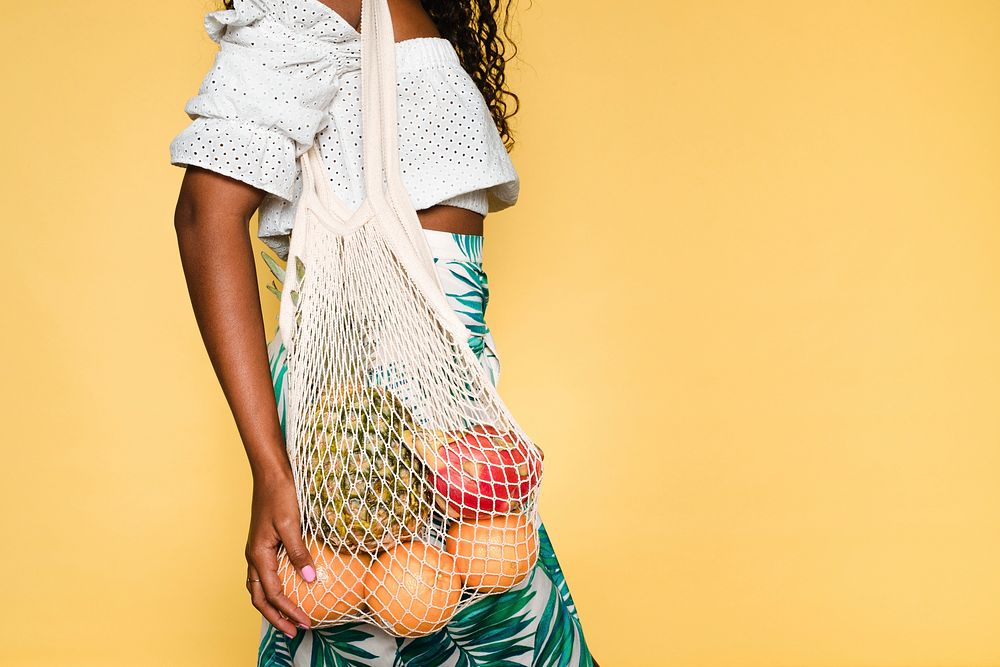 Beautiful woman using a net bag when buying fruits