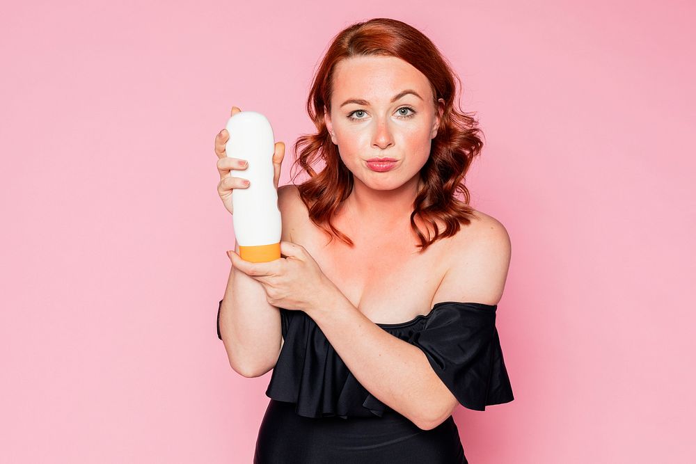 Woman holding a sunscreen tube container