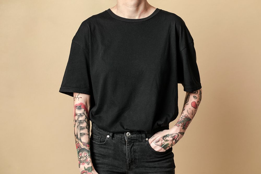 Tattooed model in black t shirt and jeans