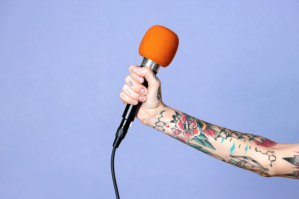 Hand with tattooed holding a microphone mockup