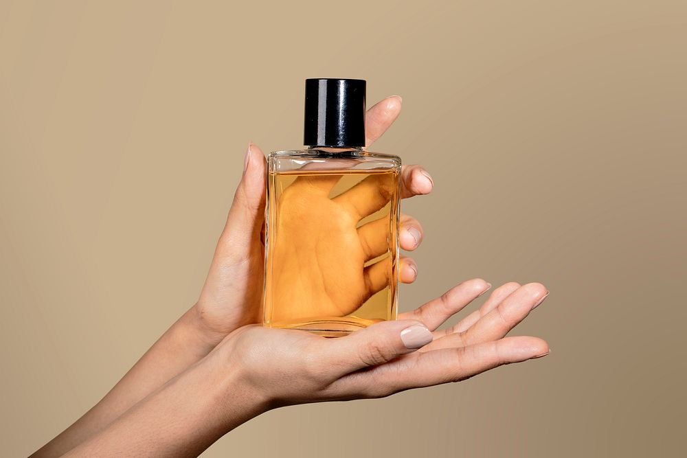 Woman holding an unlabeled perfume glass bottle