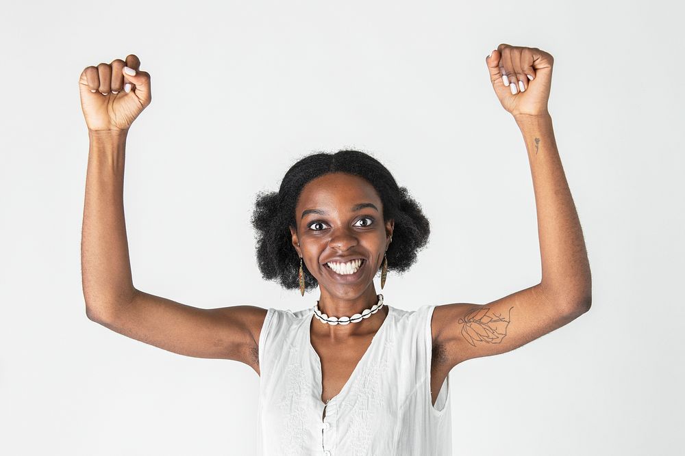 Happy black woman raising her arms 