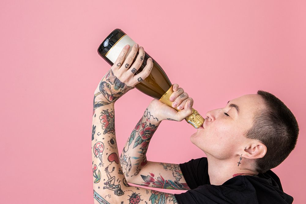 Skinhead woman drinking champagne from the bottle