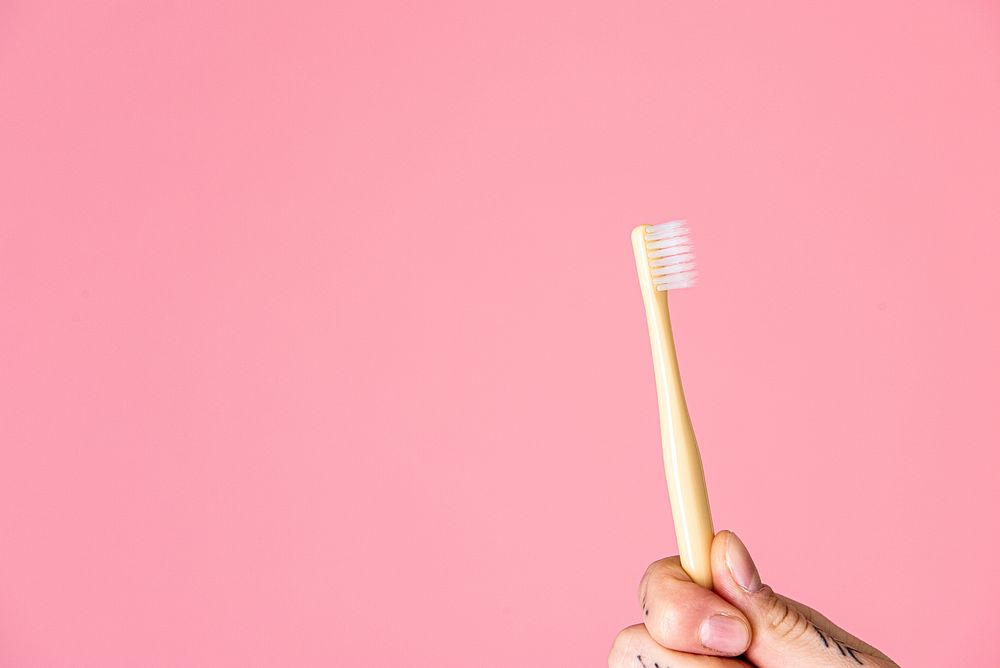 Toothbrush against a pink background 