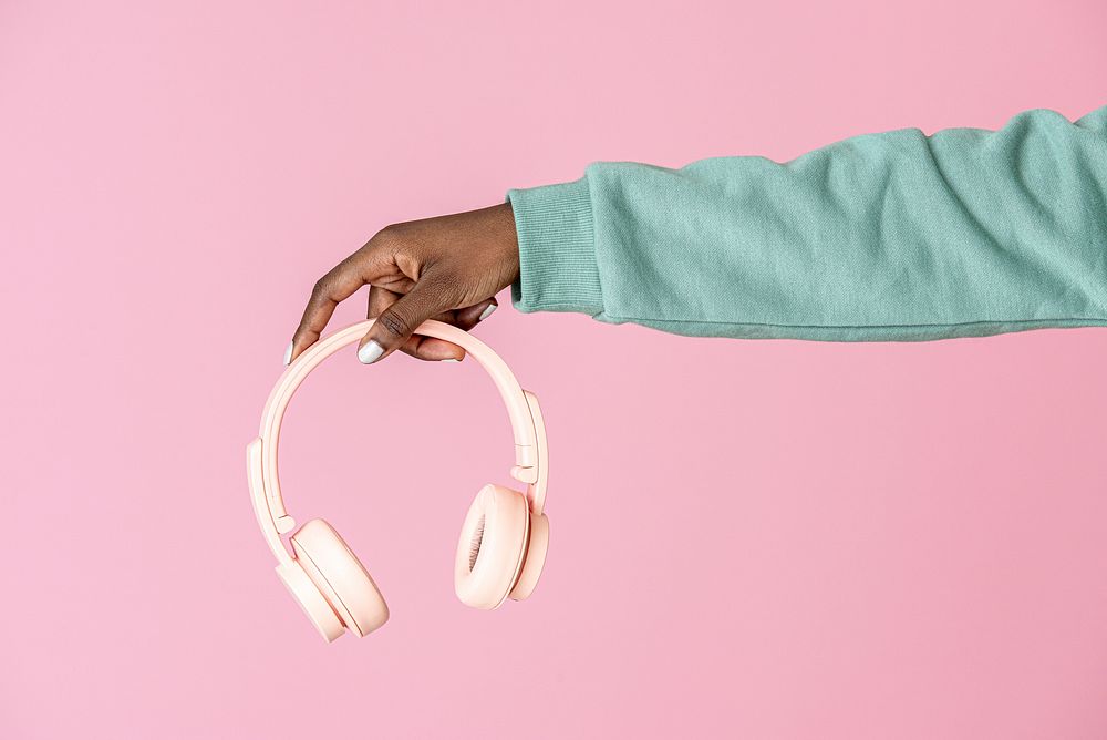 Hand holding a pink headphones