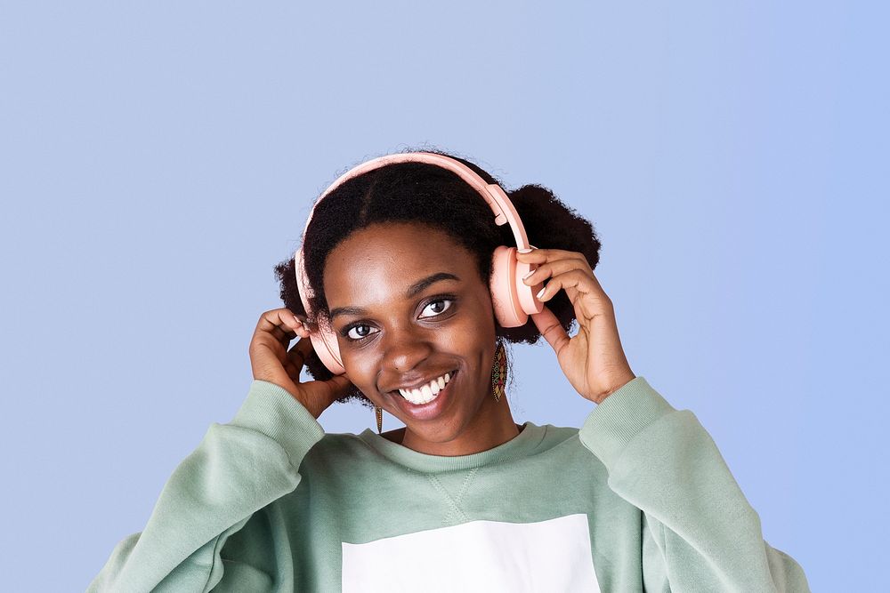 Black woman enjoying the music with blue background