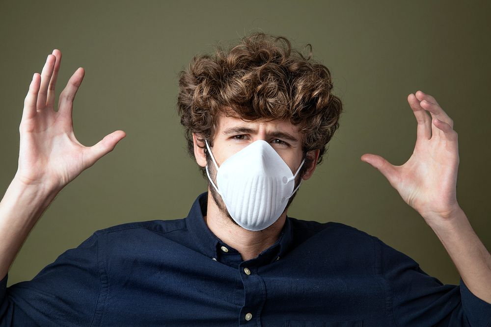 Young Caucasian man wearing a protective mask suffering from air pollution 