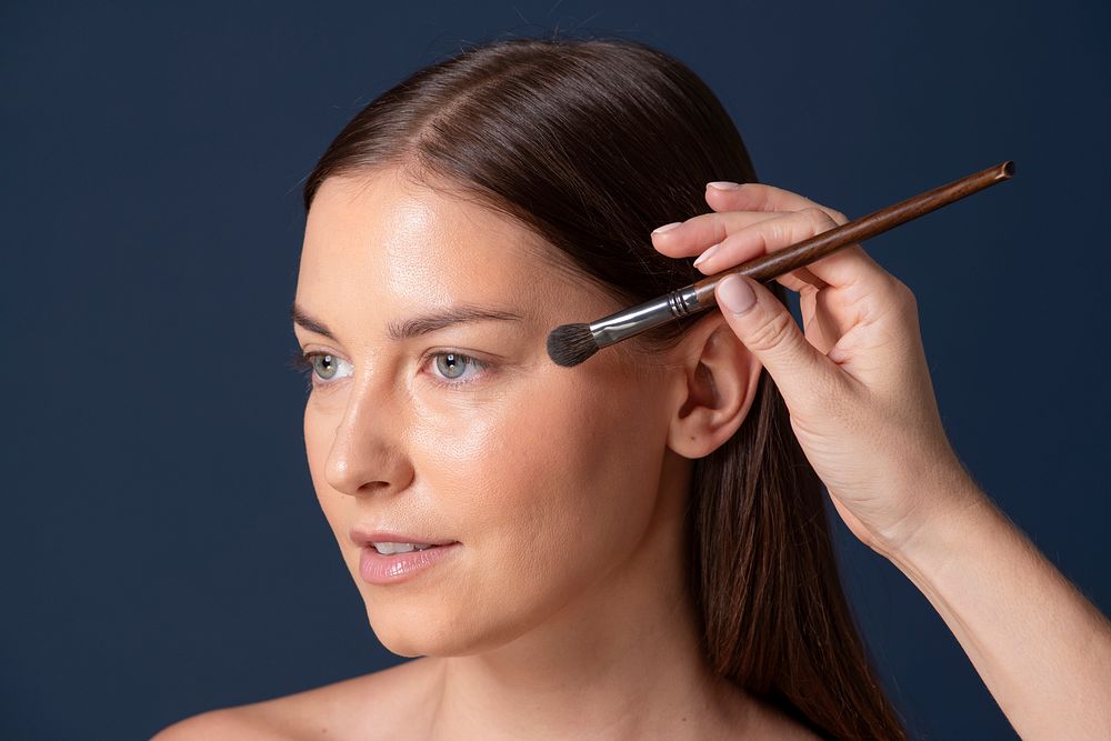 Makeup artist applying color onto a model's face
