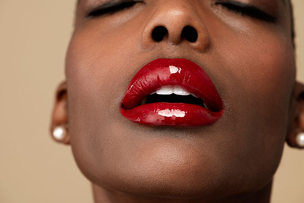 Sensual black woman wearing a glossy red lipstick