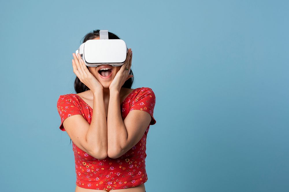 Woman having fun with a VR headset on blue background